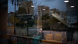 Una anciana está sentada en la sala de espera de un centro de mayores en Barcelona