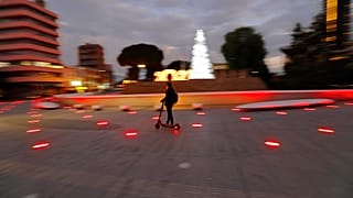 A man wearing face mask passes with a scooter by the Christmas tree at Elephteria, Liberty, square in the medieval core of capital Nicosia