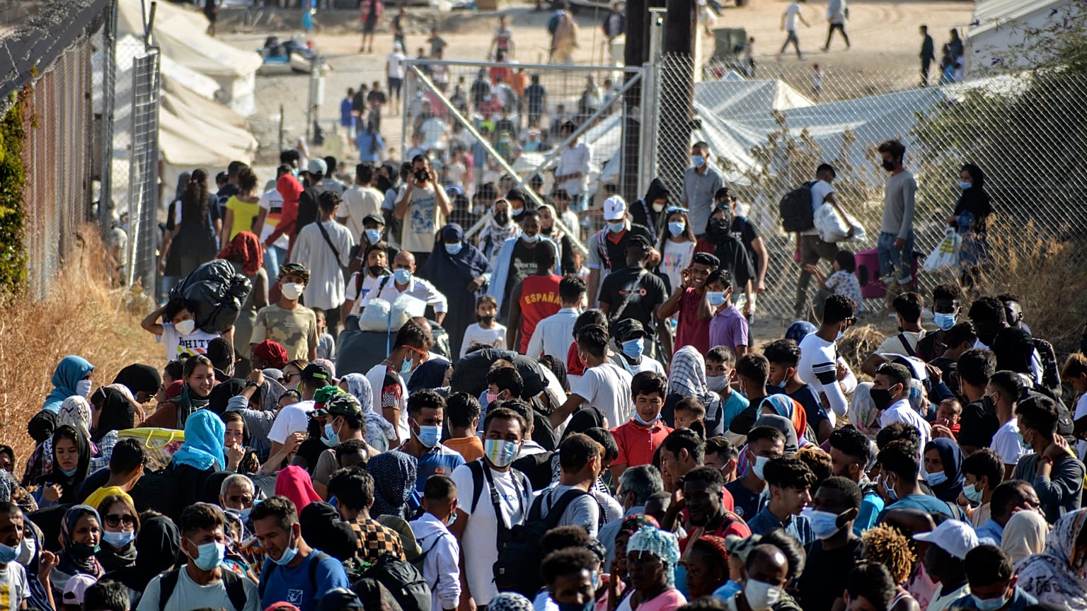 Migrants gather outside the temporary refugee camp in Kara Tepe as they wait to depart from Lesbos, Greece, Sept. 28, 2020 