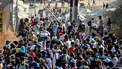 Migrants gather outside the temporary refugee camp in Kara Tepe as they wait to depart from Lesbos, Greece, Sept. 28, 2020 