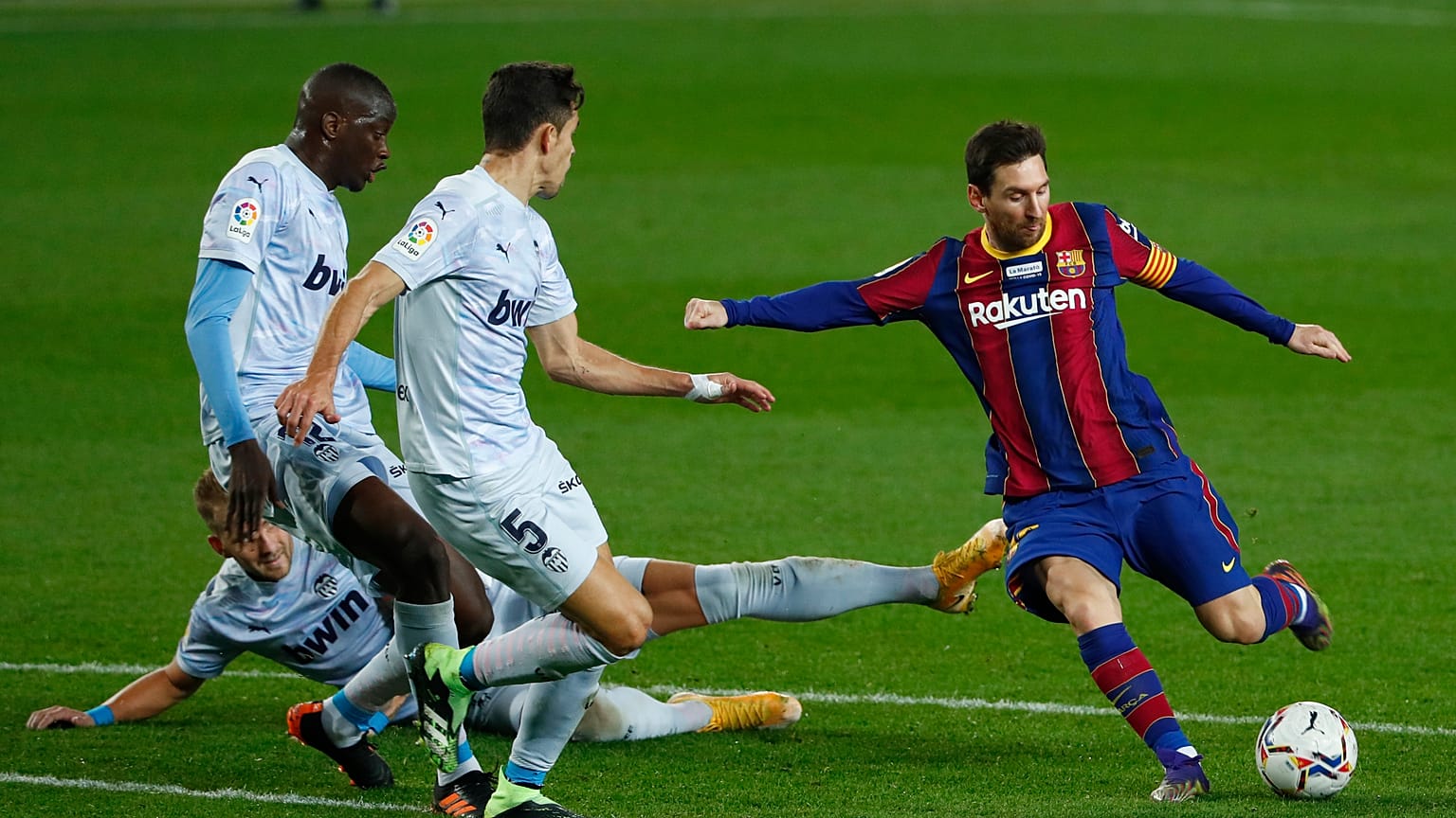 Barcelona's Lionel Messi, right, takes a shot at goal during the Spanish La Liga soccer match between Barcelona and Valencia at the Camp Nou stadium in Barcelona, Spain.