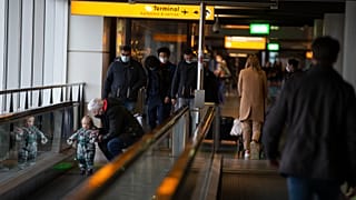 In this Friday Dec. 18, 2020, file photo, arriving and departing passengers use the flat escalators at Schiphol Airport, near Amsterdam, Netherlands.