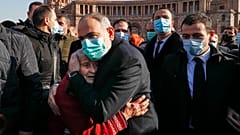 Армянский премьер Никол Пашинян обнимает плачущую женщину.