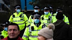 Police officers wear face masks as they patrol an anti-lockdown demonstration in Parliament Square, in London, Monday, Dec. 14, 2020. 