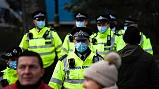 Police officers wear face masks as they patrol an anti-lockdown demonstration in Parliament Square, in London, Monday, Dec. 14, 2020. 
