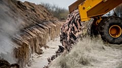 Heavy machinery is used by members of Danish health authorities, assisted by members of the Danish Armed Forces in disposing of dead mink.