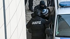 The defendant Stephan Balliet is escorted from the vehicle by court personnel upon his arrival at the district court in Magdeburg, Germany, Monday, Dec. 21, 2020.