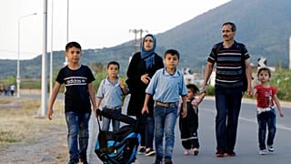 A Syrian family head to Mytilene to be counted by Greek authorities