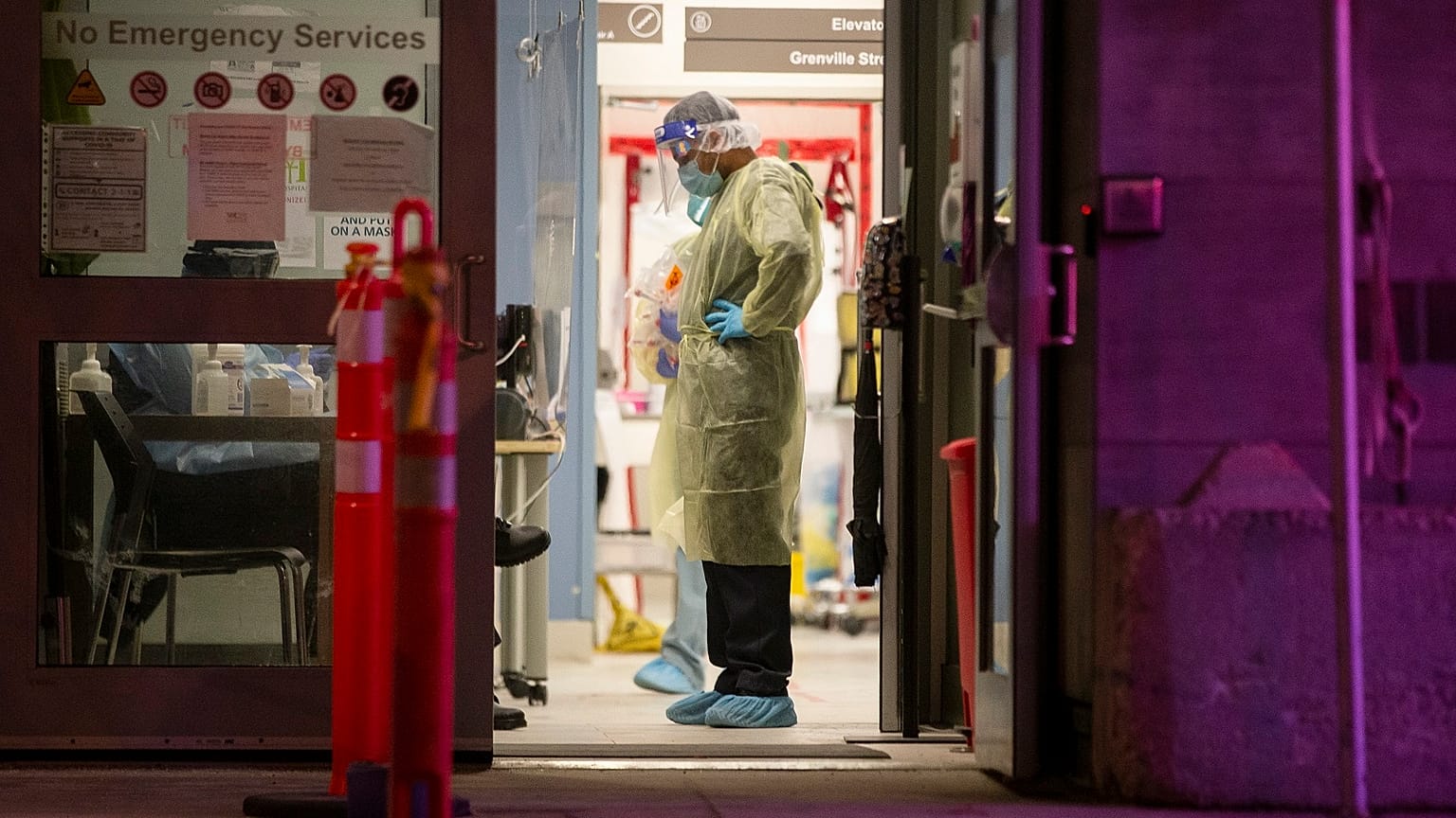 A Healthcare worker pauses during a lull in visitors at a COVID-19 testing center in Toronto, Sunday, Dec. 20, 2020.