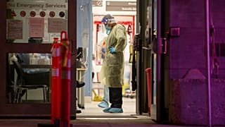 A Healthcare worker pauses during a lull in visitors at a COVID-19 testing center in Toronto, Sunday, Dec. 20, 2020.