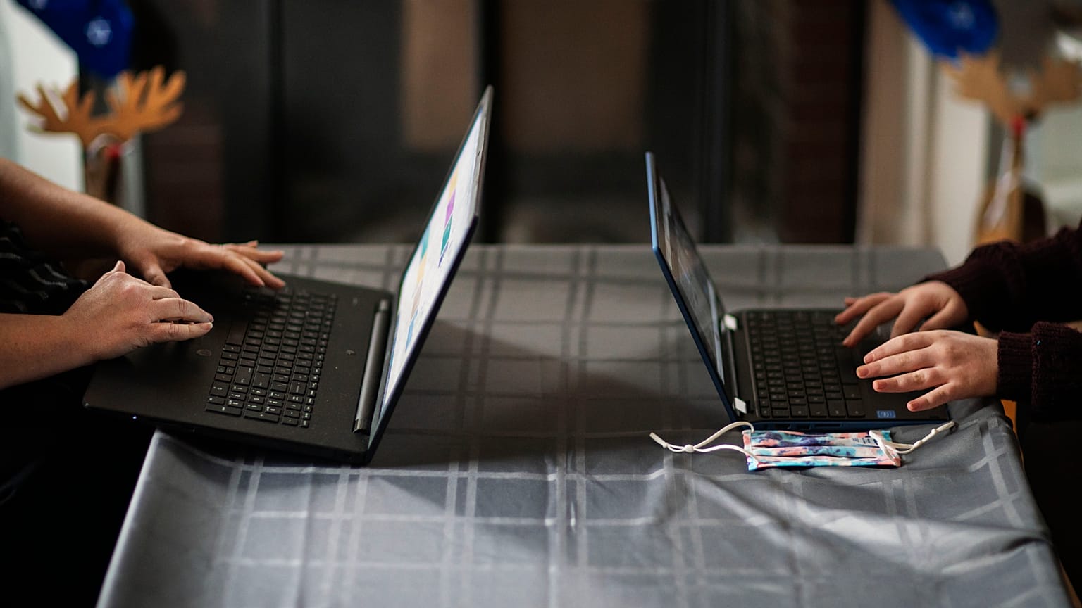 Eileen Carroll, left, works on her laptop as her daughter