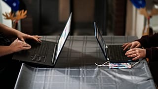 Eileen Carroll, left, works on her laptop as her daughter
