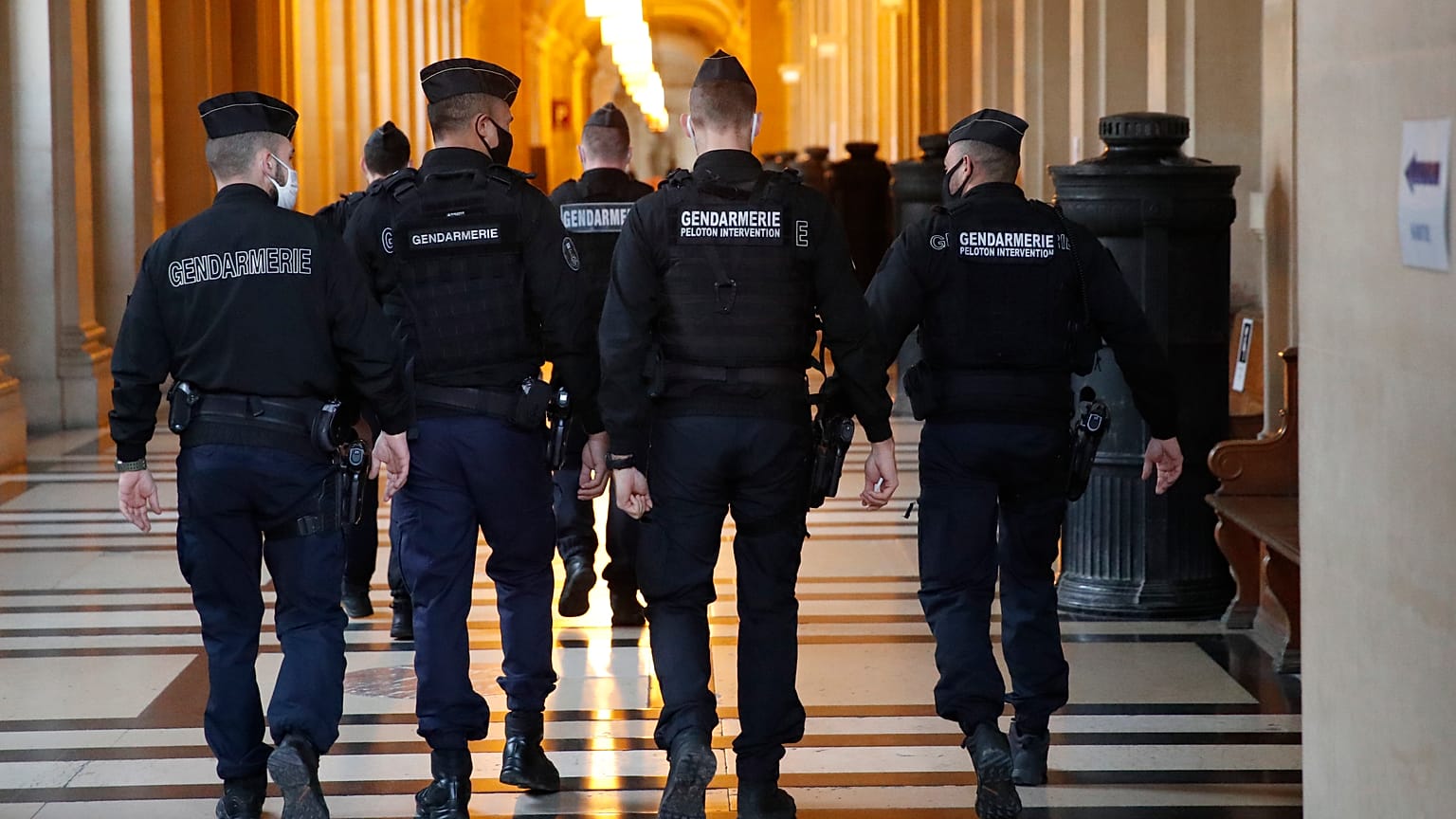 FILE: French gendarmes walk in the corridor of the hall of justice, Thursday, Dec. 17, 2020 in Paris.