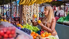 Woman shops for fresh fruit and veg in a local market