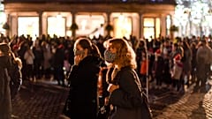 People wear face masks as they walk in Covent Garden, in London, Saturday, Dec. 12, 2020.