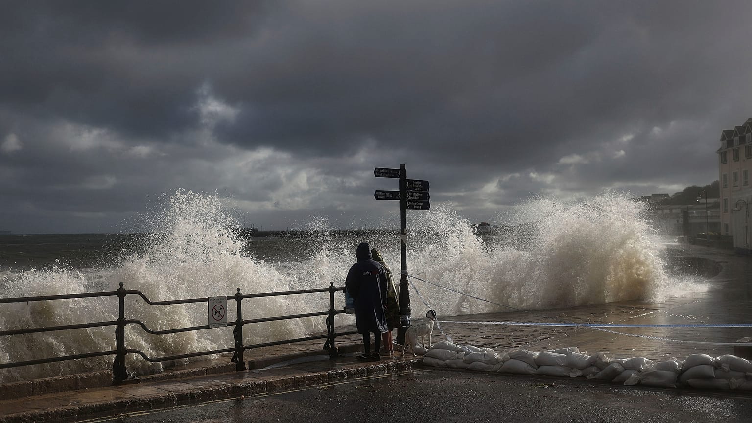 FILE PHOTO - People watch as waves crash along the coast at Swanage in Dorset, England, Friday, Oct. 2, 2020. 