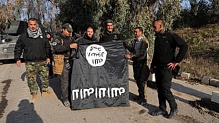 عراقيون يحملون علم داعش بعد استعادة السيطرة على الموصل