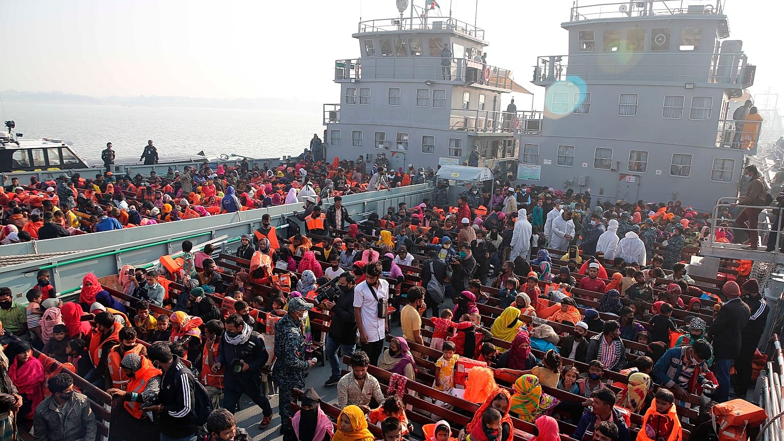Rohingya refugees settle on to naval ships to be transported to an isolated island in the Bay of Bengal, in Chittagong, Bangladesh, Tuesday, Dec. 29, 2020.