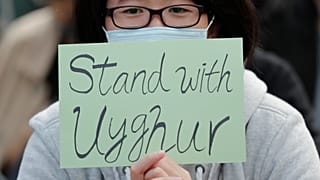 Hong Kong'da düzenlenen gösteriler sırasında Uygurlarla dayanışma içerisinde olduğunu belirten bir döviz taşıyan eylemci