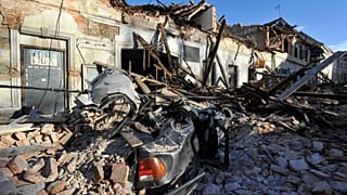 Resti di un'auto coperta da detriti e di edifici danneggiati dal terremoto a Petrinja, Croazia