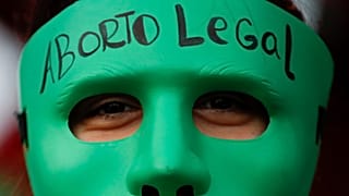 Attivista pro-aborto in Argentina con una maschera del colore verde, quello scelto dalla campagna per il sì all'interruzione di gravidanza