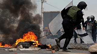 Policías retiran una barricada en la carretera Panamericana en Virú, Perú