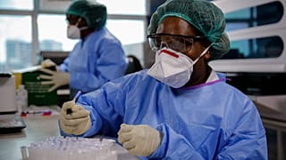 Kenya'nın başkenti Nairobi'de koronavirüs testini inceleyen sağlık görevlileri