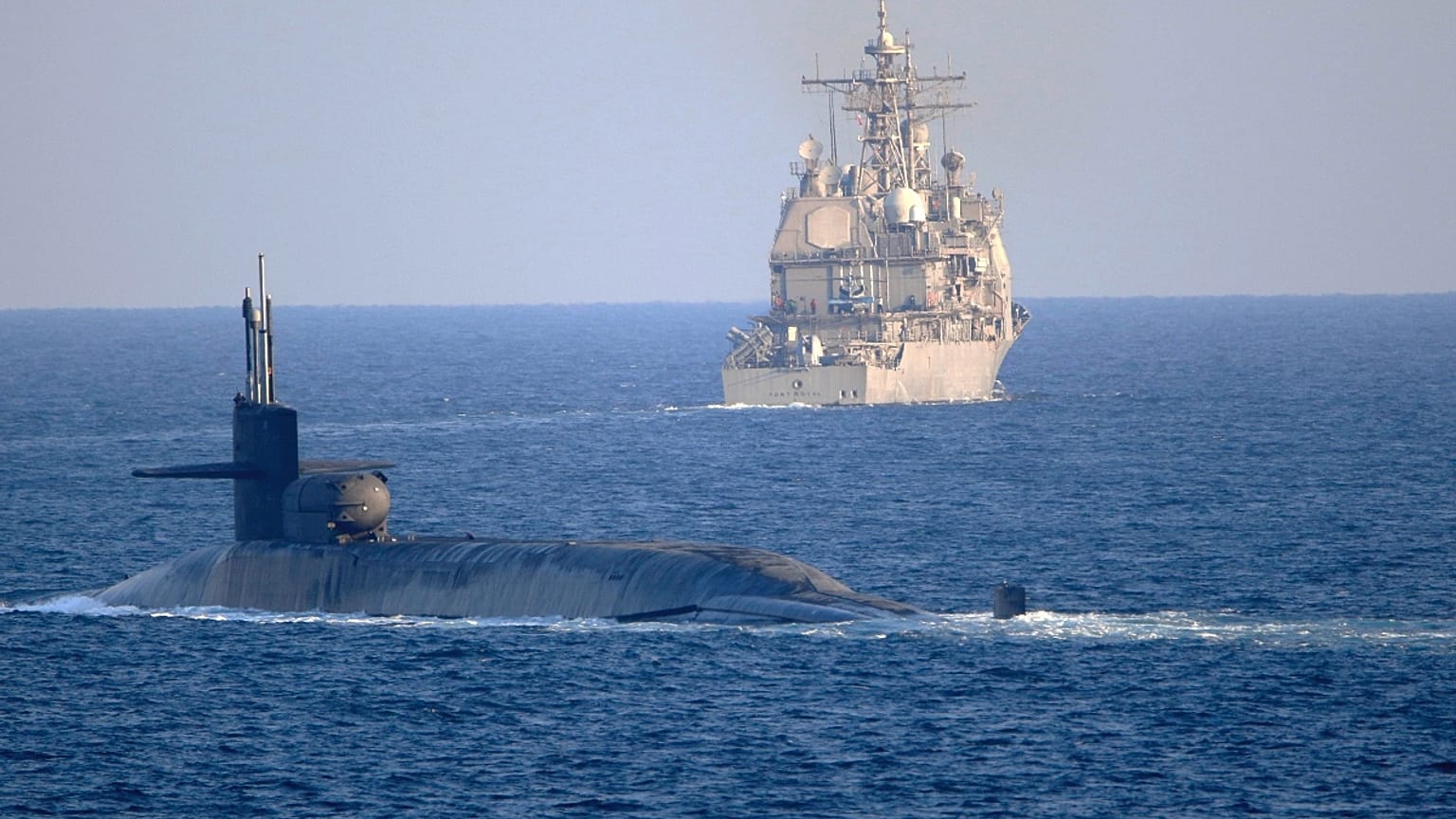 submarine USS Georgia, front, with the guided-missile cruiser USS Port Royal, transit the Strait of Hormuz in Persian Gulf