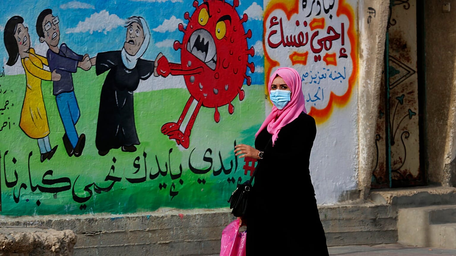 Nő sétál el az egyik graffiti előtt 