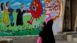 Nő sétál el az egyik graffiti előtt 