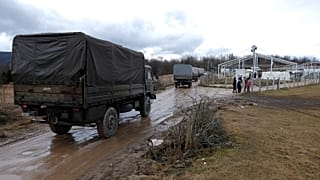 Bosnian soldiers arrive at the Lipa refugee camp outside Bihac, to erect tents for some hundreds of migrants who have been stuck in a burnt out camp.