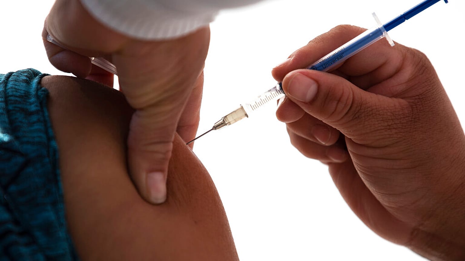 A health worker gets a shot of the Pfizer-BioNTech vaccine for COVID-19