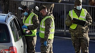 Soldiers carry out a COVID test on a driver at the entrance to The Port of Dover in Kent, England, Friday, Dec. 25, 2020.