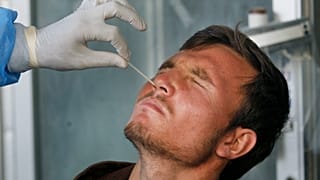 Orrból vesznek mintát PCR-teszthez a pakisztáni Karacsiban 2020. december 30-án