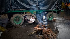 Un contadino si riposa sotto al suo trattore al confine tra gli Stati di Delhi e Uttar Pradesh, in India, lunedì 4 gennaio 2021