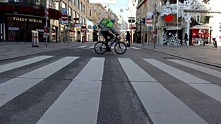 A cyclist drives on a shopping street in downtown Vienna, Austria