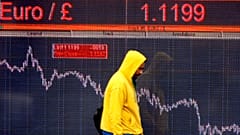 A pedestrians passes an electronic display sign showing the euro to pound rate in London, Friday, Dec. 12, 2008.
