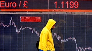 A pedestrians passes an electronic display sign showing the euro to pound rate in London, Friday, Dec. 12, 2008.
