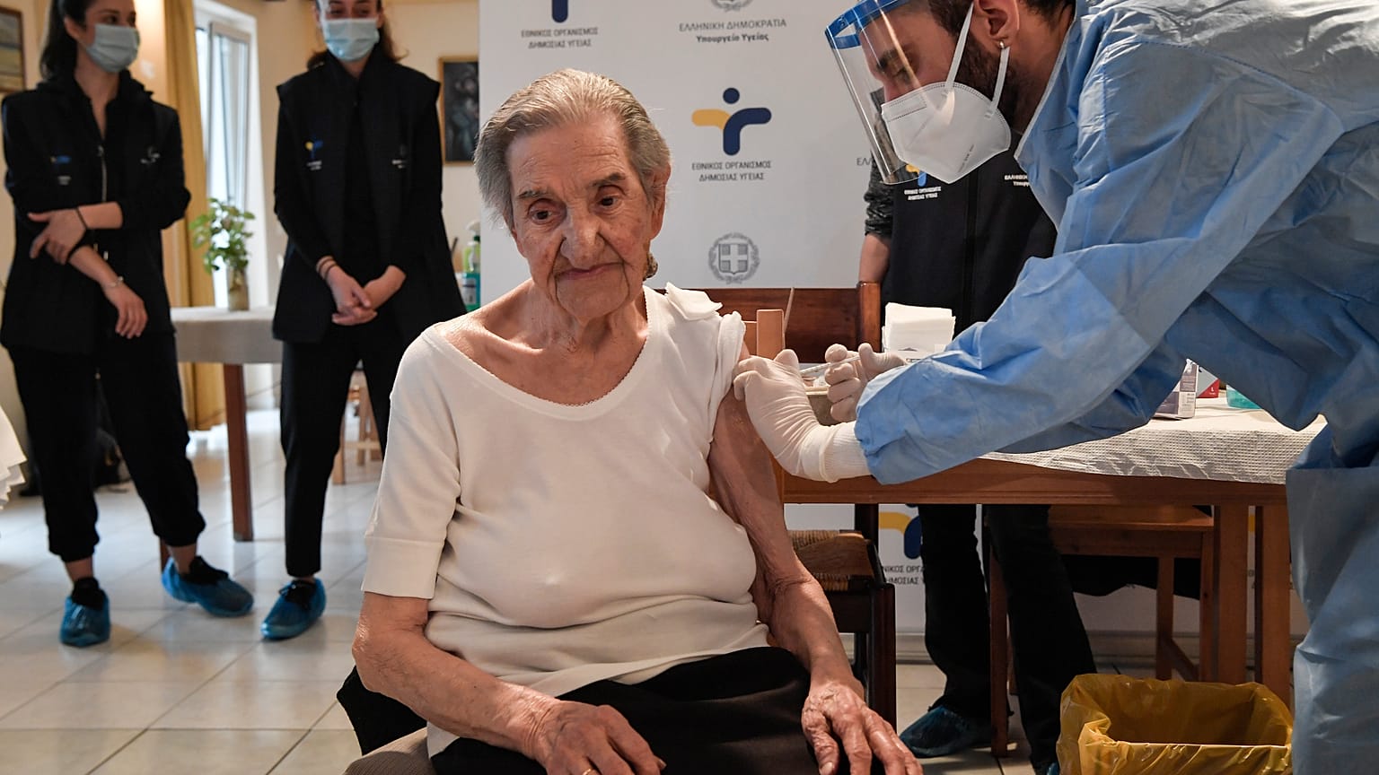 An elderly woman gets a vaccination at a nursing house in Athens, Monday, Jan. 4, 2021