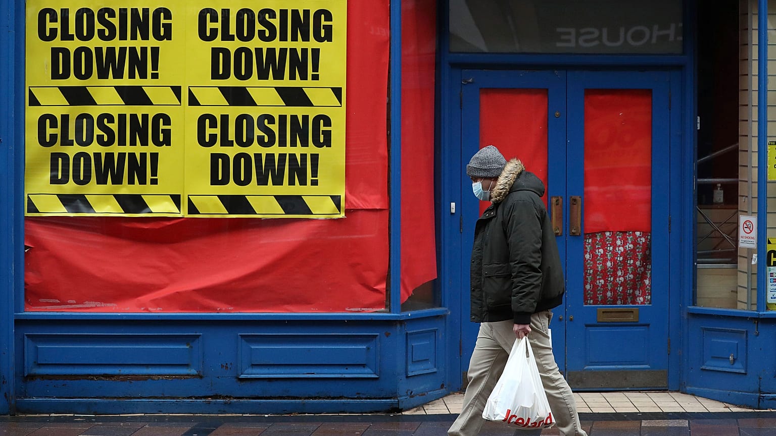 Una persona pasa ante una tienda cerrada en Escocia