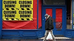 Una persona pasa ante una tienda cerrada en Escocia