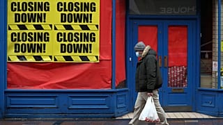 Una persona pasa ante una tienda cerrada en Escocia