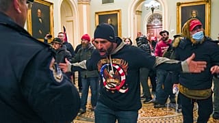 Partidarios de Trump se encaran contra la policía del Capitolio de EE.UU. en el pasillo fuera de la cámara del Senado en el Capitolio de Washington, el miércoles 6 de enero.