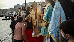 Константинопольский патриарх Варфоломей встречает верующего, который окунался за крестом в Босфор