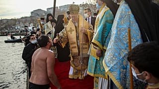 Константинопольский патриарх Варфоломей встречает верующего, который окунался за крестом в Босфор