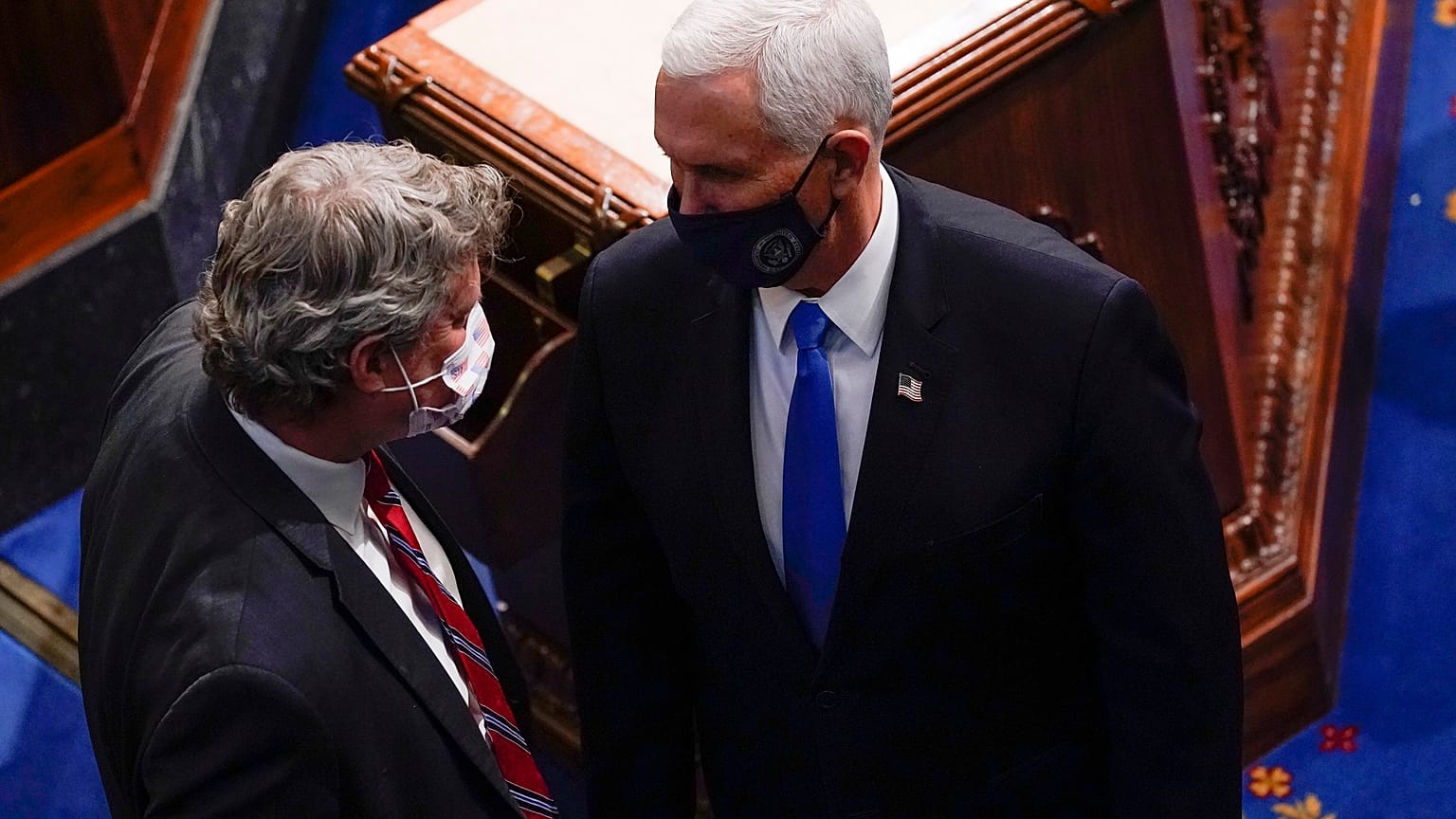 El vicepresidente Mike Pence habla con el representante republicano por Michigan Bill Huizenga durante una sesión conjunta del Congreso
