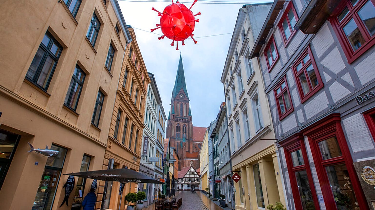 Coronavirus-Lampion hängt über einer Einkaufsstraße vor dem Turm des Schweriner Doms, 5.1.2021
