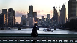 A man walks over Westminster Bridge as the sun sets in London, Wednesday, Jan. 6, 2021.