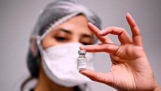 Сотрудница больницы в столичном регионе Франции с ампулой вакцины Pfizer/BioNTech