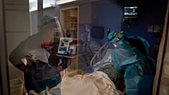 Registered nurses Kyanna Barboza, right, tends to a COVID-19 patient as Kobie Walsh puts on her PPE at St. Joseph Hospital in Orange, Calif. Thursday, Jan. 7, 2021